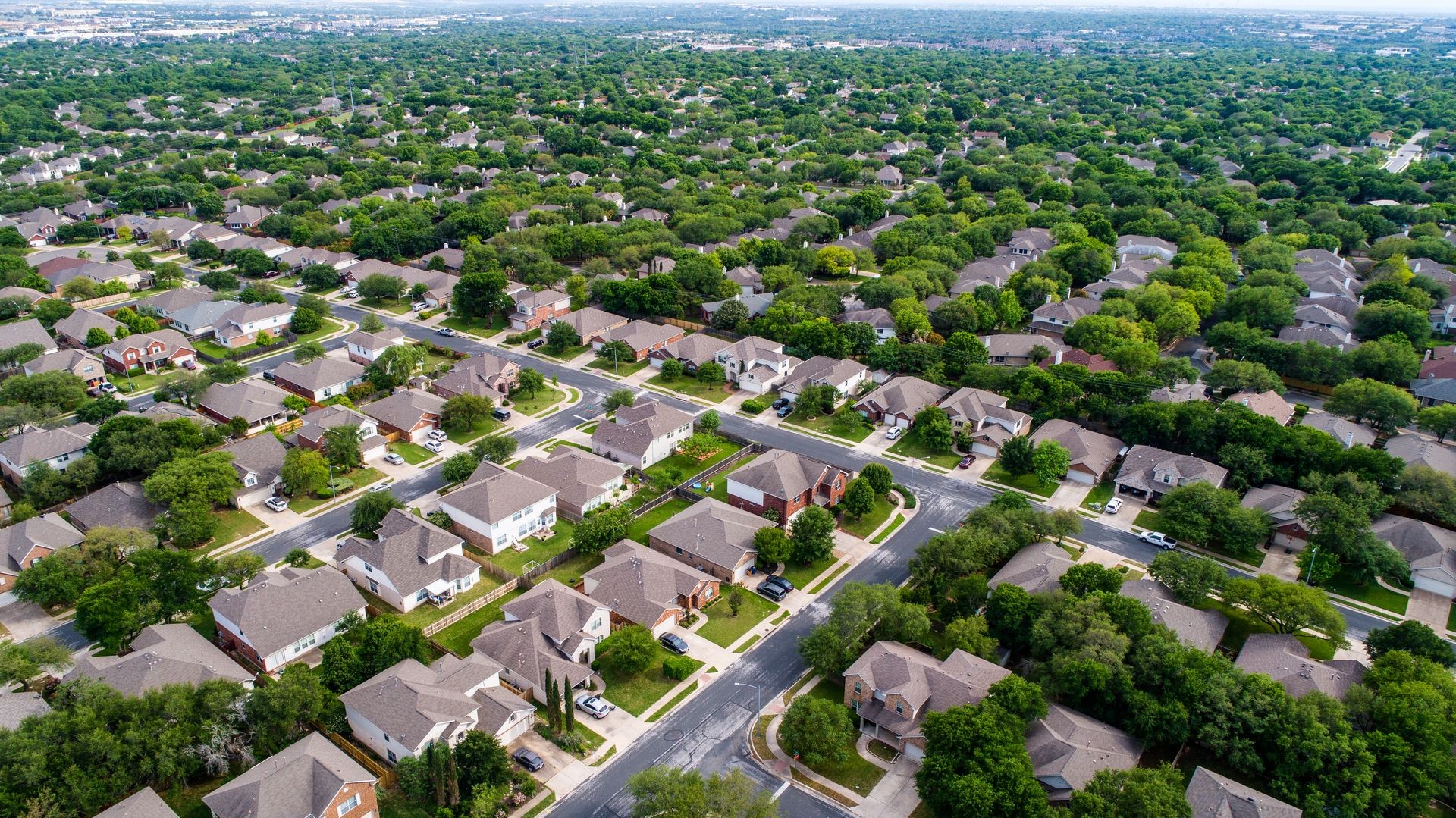 Suburb houses and homes in new real estate development in Austin , Texas , USA aerial drone view green Texas hill country landscape with suburb suburbia neighborhood